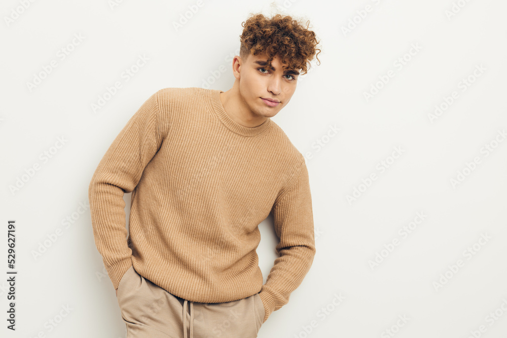 horizontal photo of a cute, neutrally emotional man in a beige sweater looking at the camera horizontal photo of a cute, neutrally emotional man in a beige sweater looking at the camera
