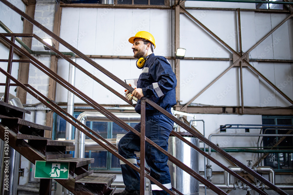 Factory worker walking through production plant. Factory worker walking through production plant.