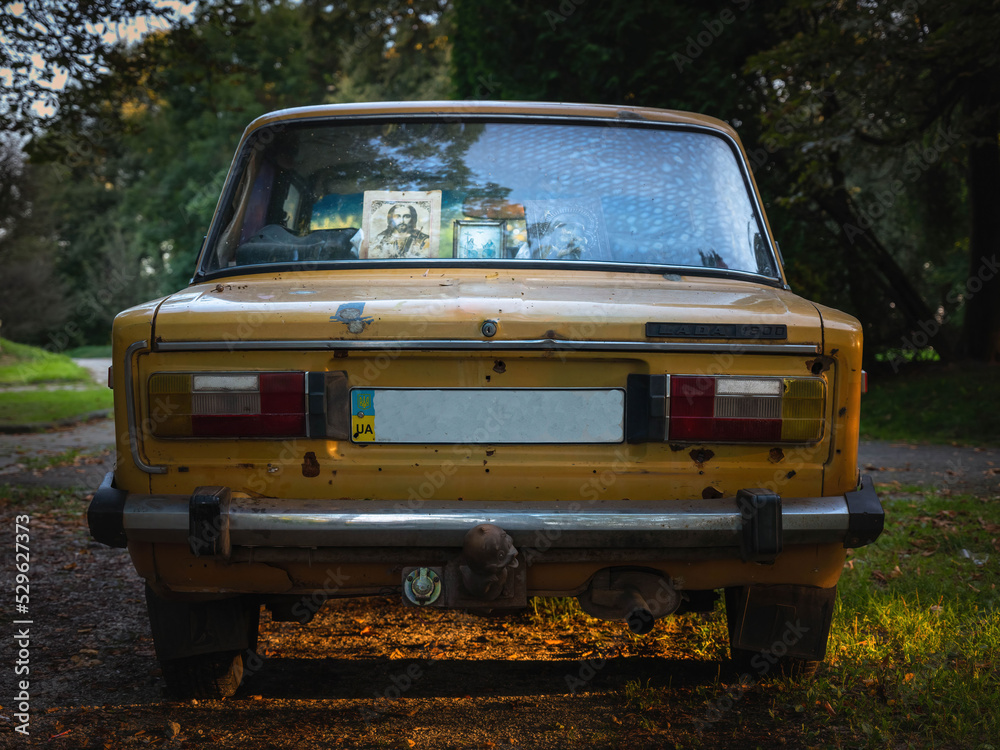 Stary samochód marki Łada z Ukrainy ze świętymi obrazkami na tylnej szybie - fugigfx, średni format - obrazy, fototapety, plakaty 