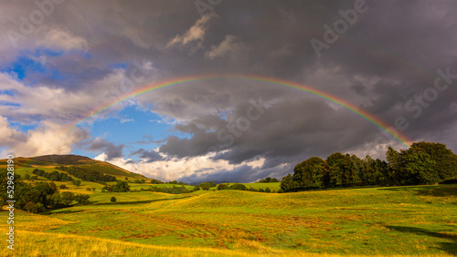 Rainbow over green hills in North UK.