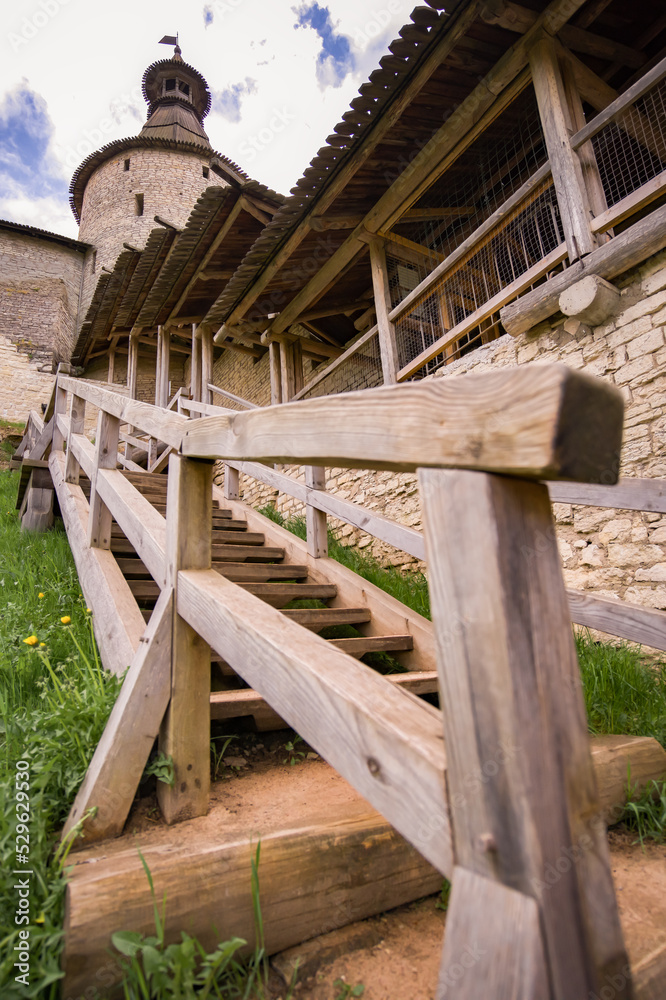 Pskov Kremlin on the Velikaya River, a stone fortress wall with a watchtower. The city of Pskov