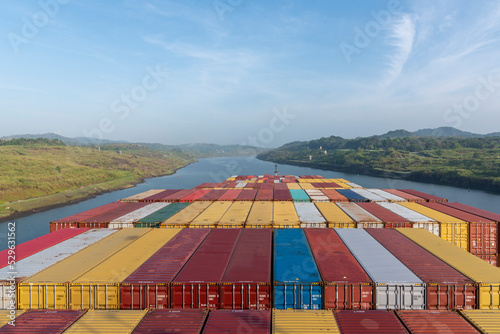 View on the top of the containers loaded on deck of the large cargo ship. She is sailing through the Panama Canal.