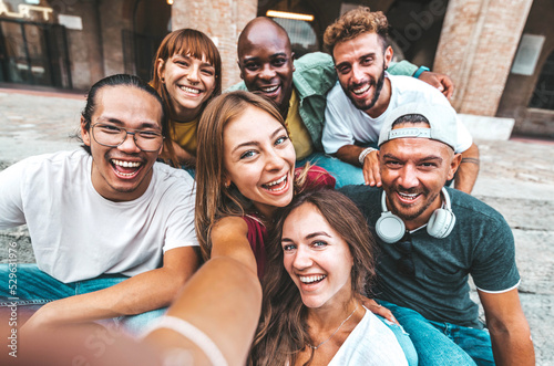 Happy multiracial friends taking selfie with smart mobile phone outdoors - Group of young people having fun together hanging out on city center - Friendship and youth lifestyle concept