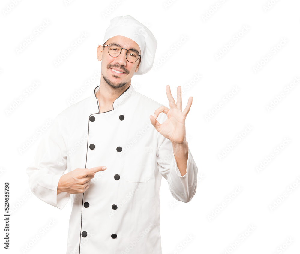 Happy young chef doing an all right gesture