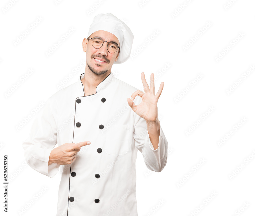 Happy young chef doing an all right gesture Happy young chef doing an all right gesture