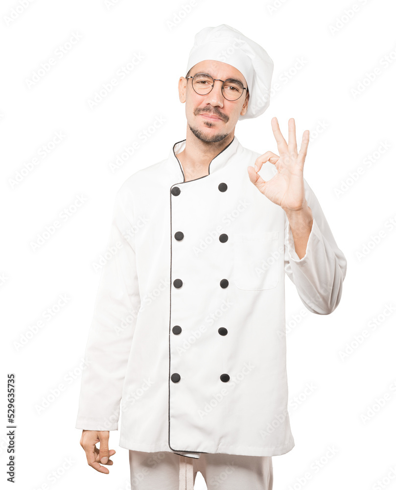 Happy young chef doing an all right gesture Happy young chef doing an all right gesture