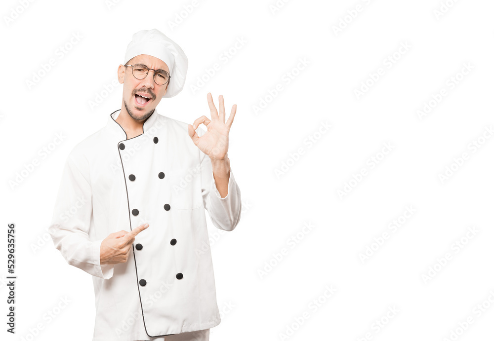 Surprised young chef with a gesture of approval Surprised young chef with a gesture of approval