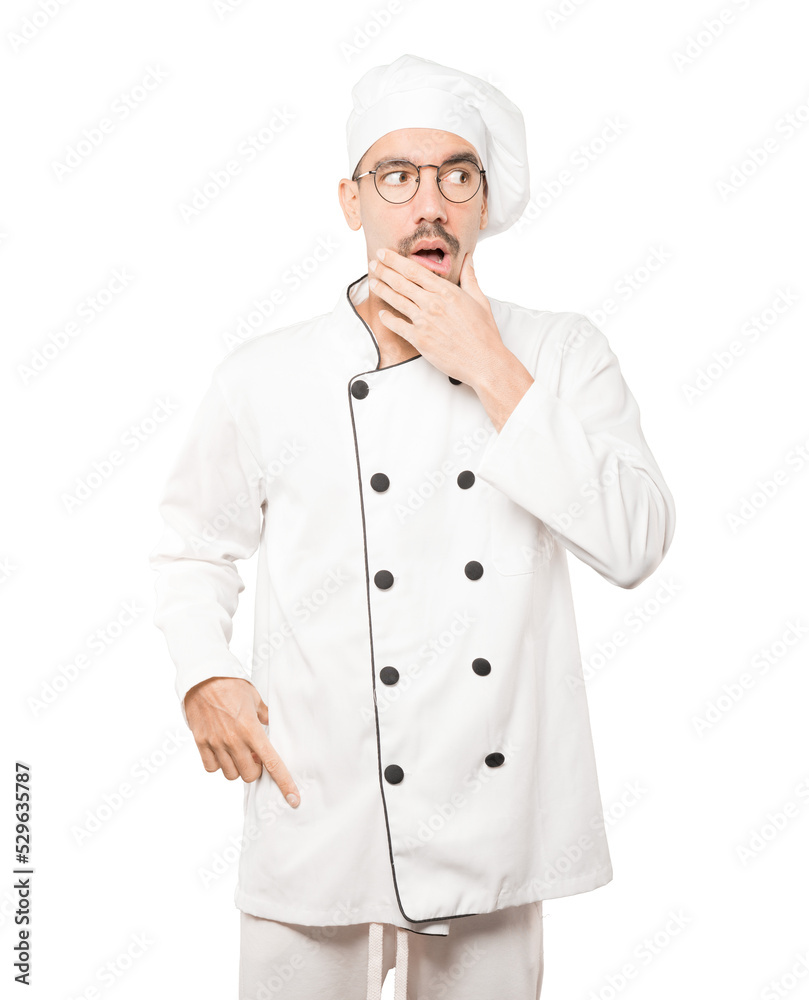 Astonished young chef with a gesture of shock Astonished young chef with a gesture of shock