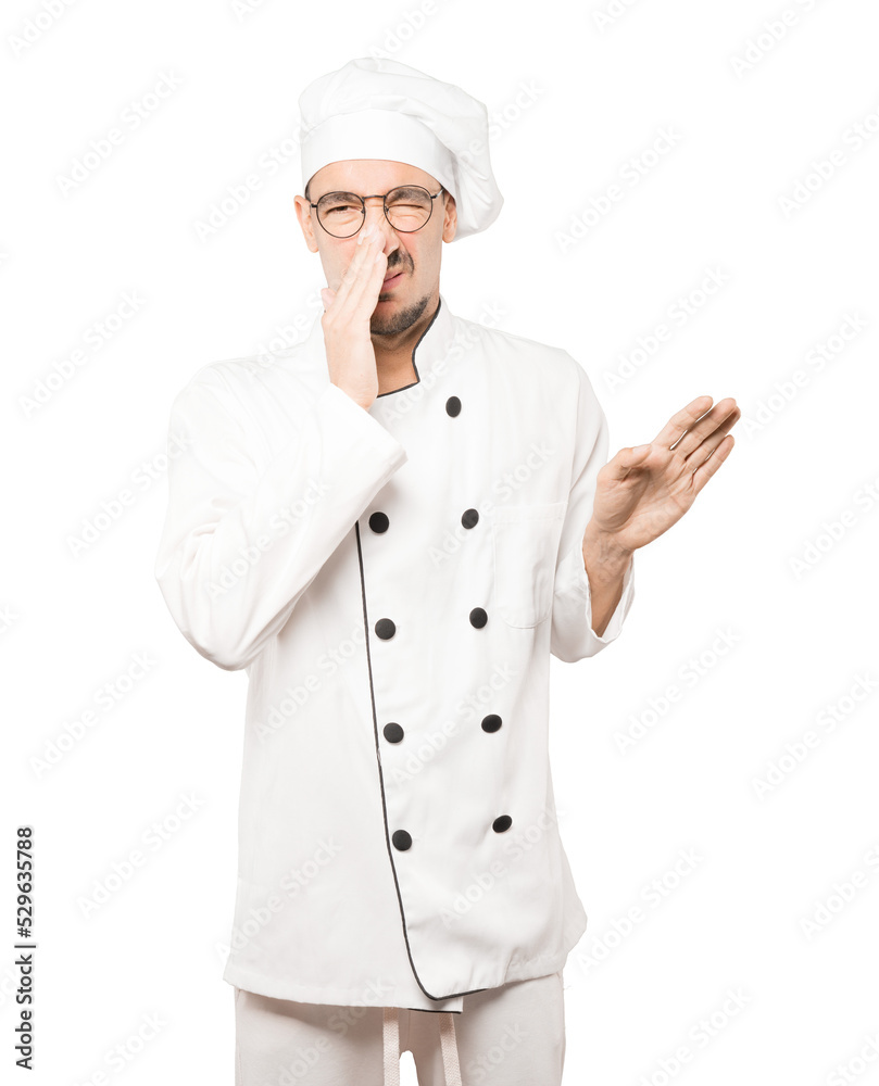 Concerned young chef with a gesture of disgust Concerned young chef with a gesture of disgust