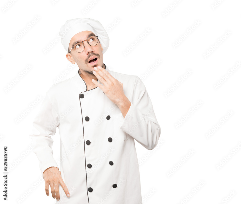 Astonished young chef with a gesture of shock Astonished young chef with a gesture of shock