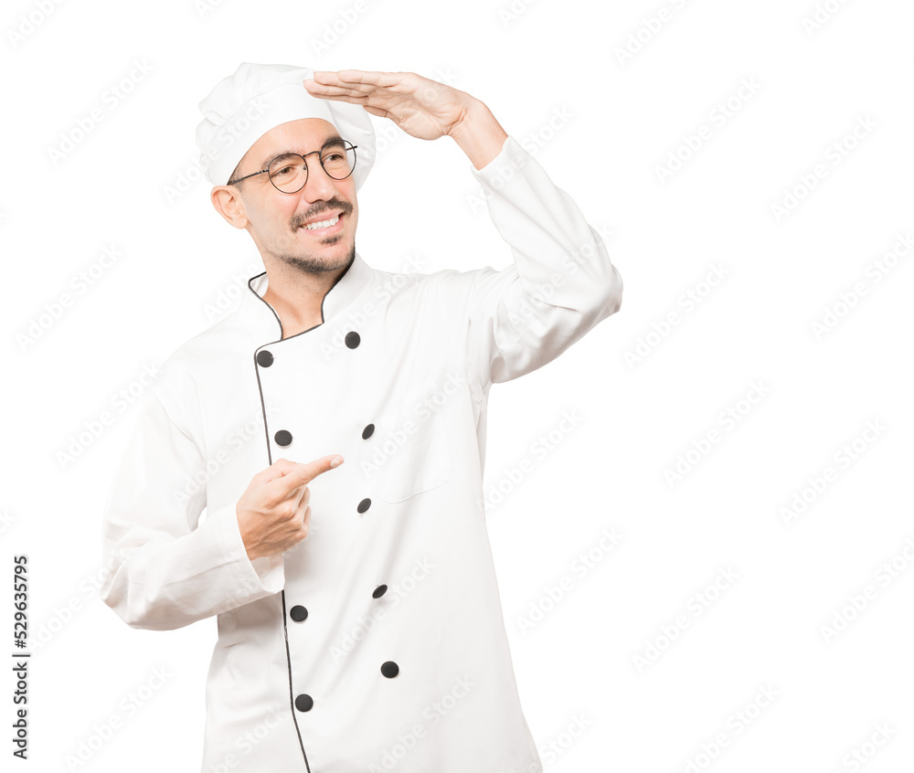 Happy young chef with a gesture of looking away