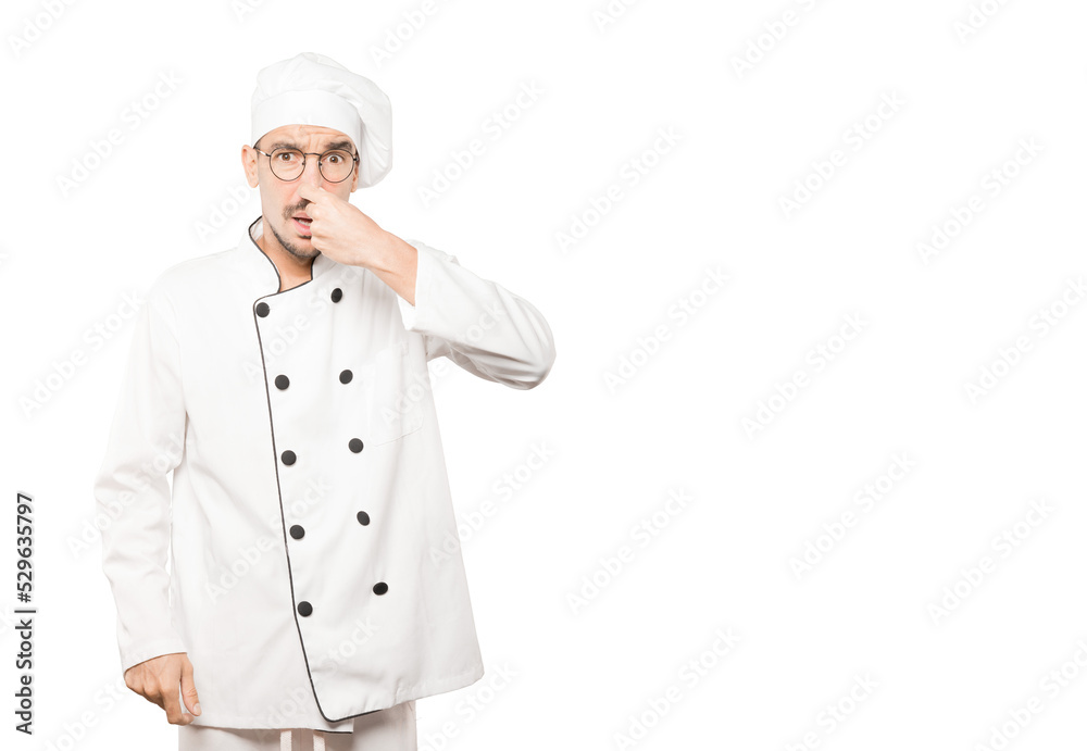 Concerned young chef with a gesture of disgust