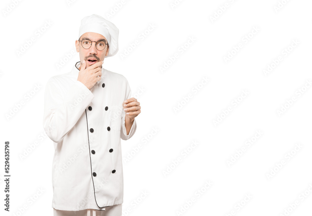 Astonished young chef with a gesture of shock Astonished young chef with a gesture of shock