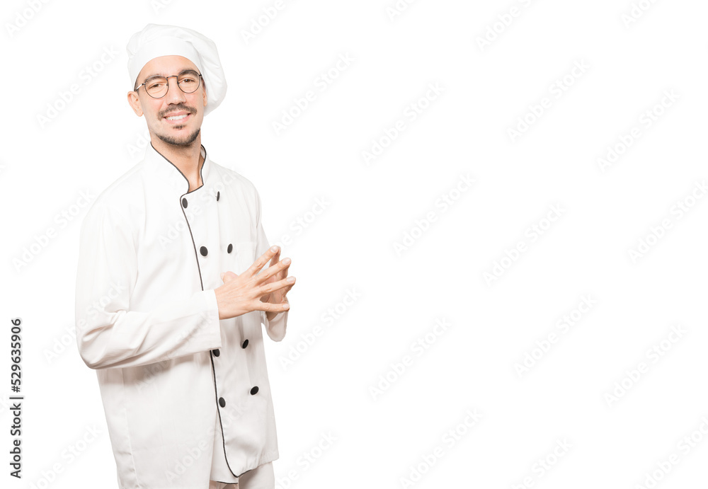 Friendly young chef doing a gesture of confidence Friendly young chef doing a gesture of confidence