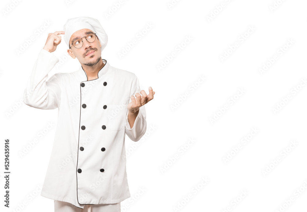 Concerned young chef doing a gesture of confusion Concerned young chef doing a gesture of confusion