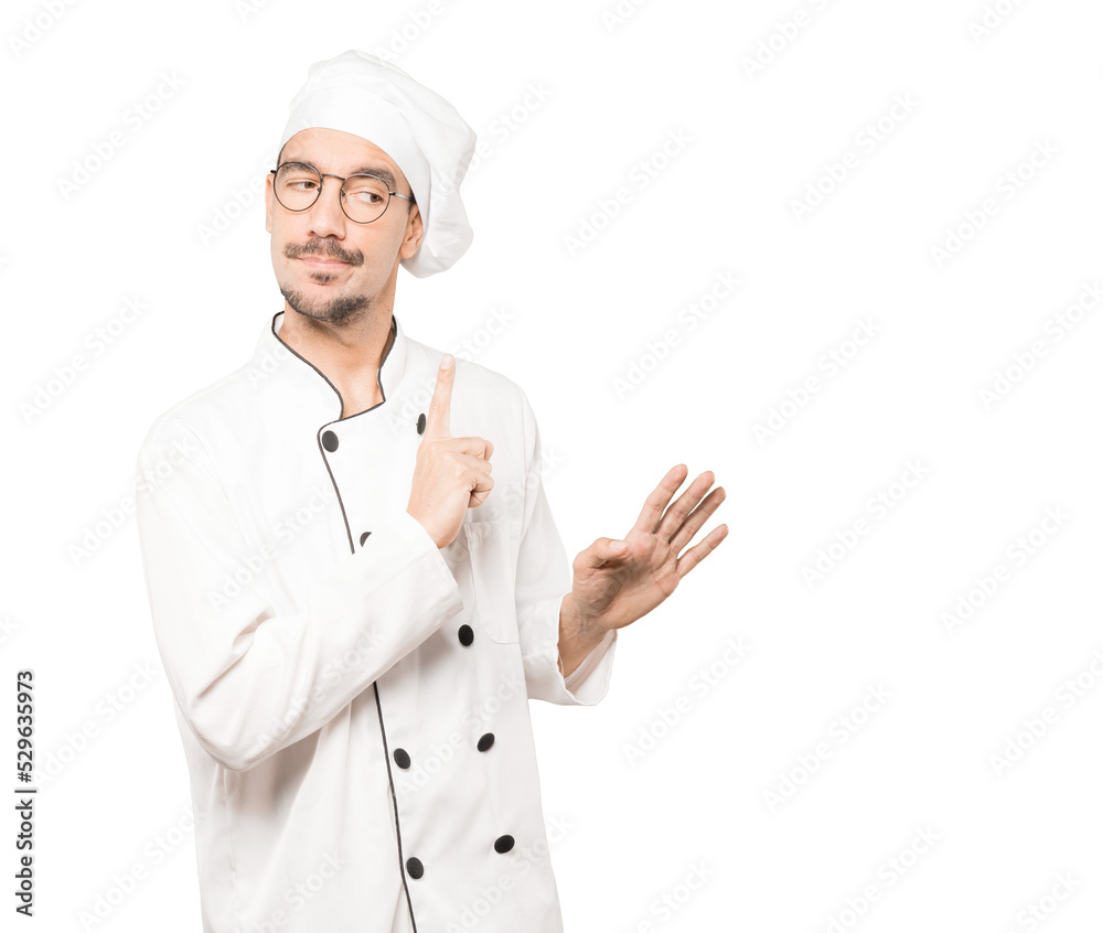 Haughty young chef making a contemptuous gesture Haughty young chef making a contemptuous gesture
