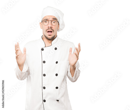 Crazy young chef making a gesture of despair