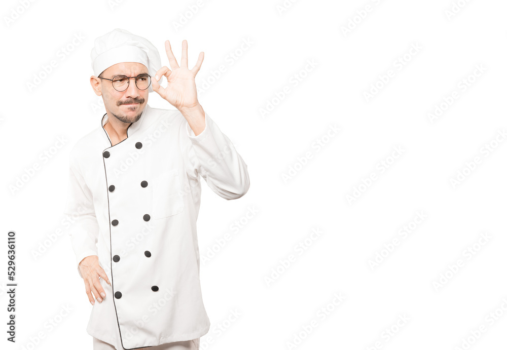 Amazed young chef using his hands like a binoculars Amazed young chef using his hands like a binoculars