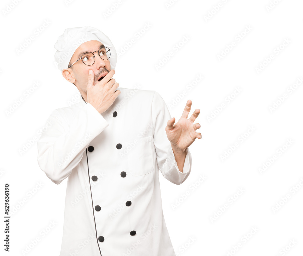 Scared young chef screaming against background Scared young chef screaming against background