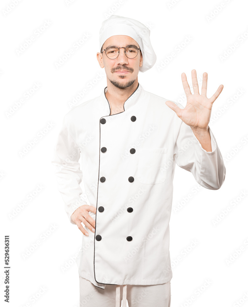 Young chef making a number five gesture Young chef making a number five gesture