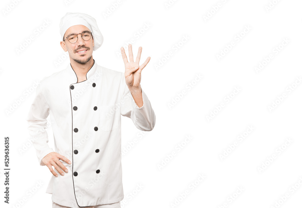 Young chef making a number four gesture