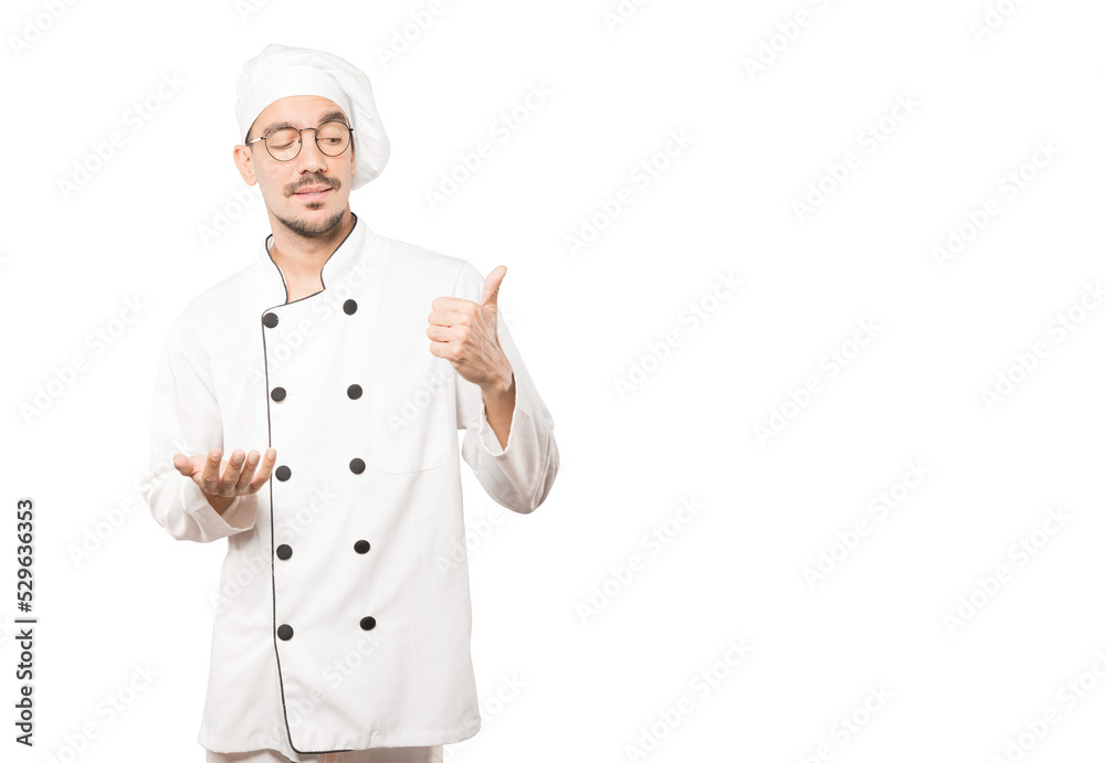 Hesitant young chef gesturing that everything is fine Hesitant young chef gesturing that everything is fine