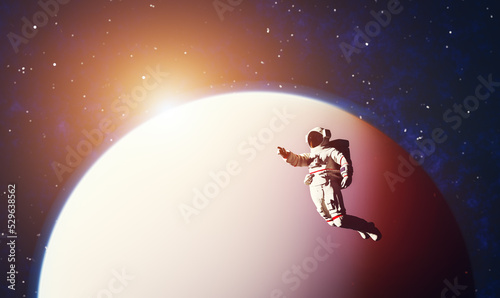 Astronaut spacewalk in space near a planet and pointing his finger. #529638562