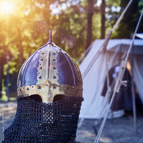 Medieval dark helmet with chain mail and golden applications photo