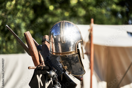 Bright shiny silver medieval knight helmet with reflections of sun rays photo