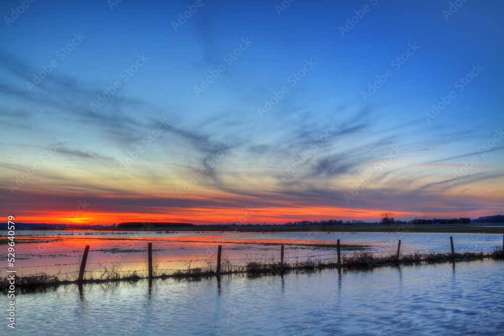 Landscape sunset or sundown river Narew Poland Europe spring time meadows under water