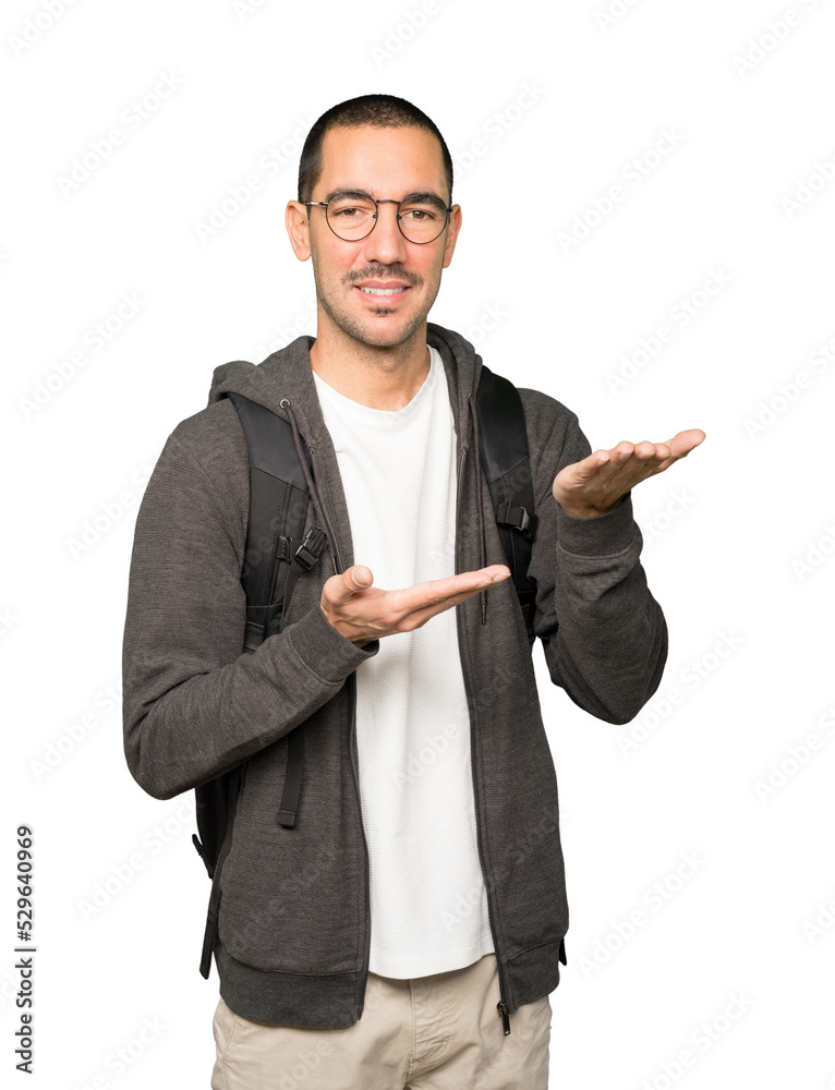 Happy student holding something with his hand Happy student holding something with his hand