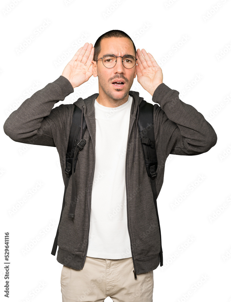 Concentrated student making a gesture of trying to hear something Concentrated student making a gesture of trying to hear something