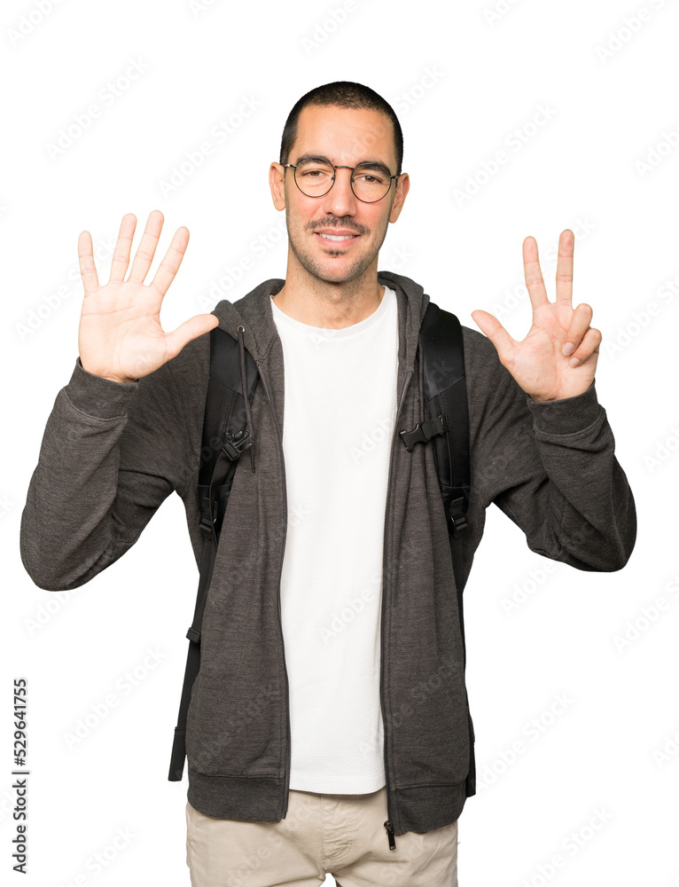 Happy student doing a number eight gesture with his hands Happy student doing a number eight gesture with his hands