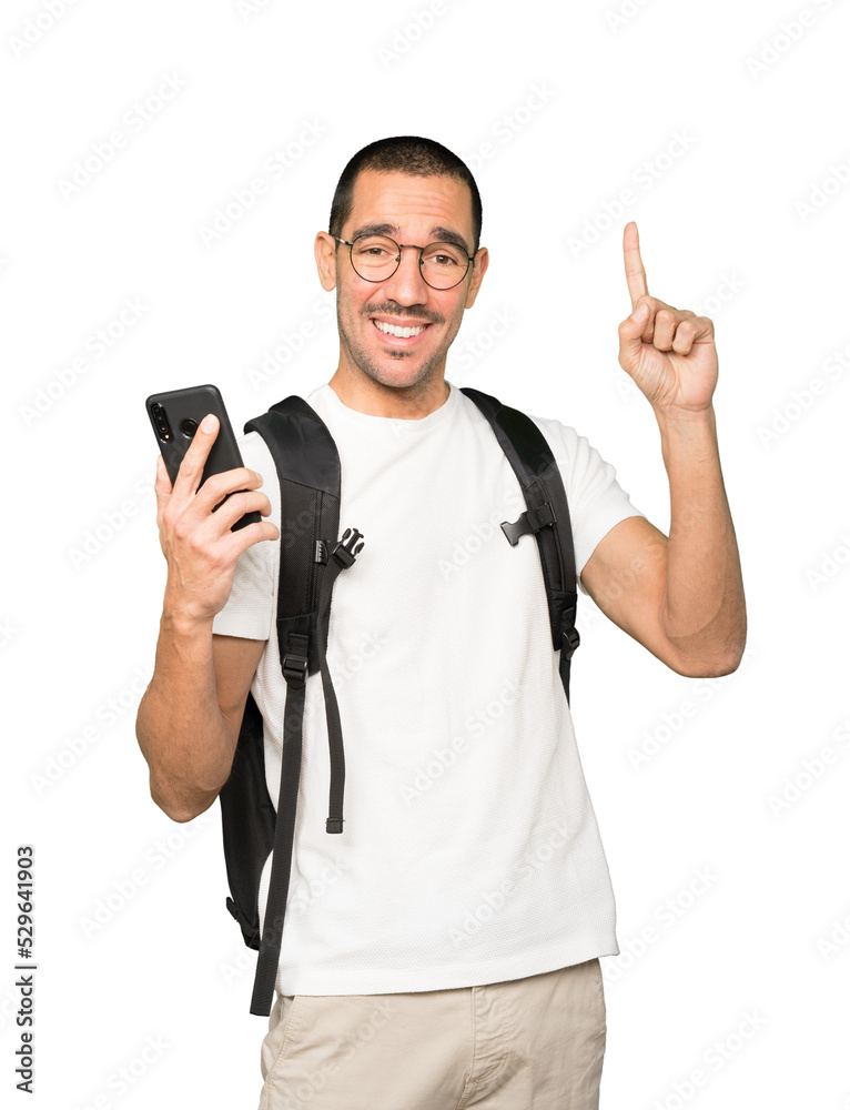 Happy student using a mobile phone and pointing up Happy student using a mobile phone and pointing up