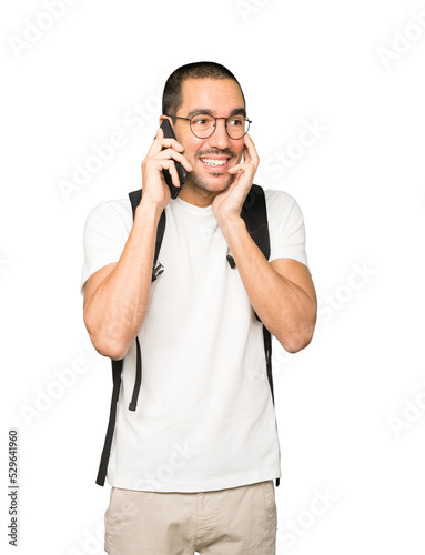 Surprised student pointing and using his mobile phone