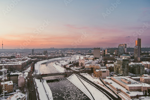 Beautiful Vilnius city panorama in winter with snow covered houses, churches and streets. Aerial evening view. Winter city scenery in Lithuania.