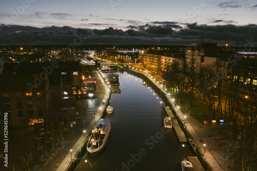 Aerial view of cityscape of Klaipeda at night. Yachts and boats docked along the embarkment of Dane river. Nightlife of Klaipeda, Lithuania.