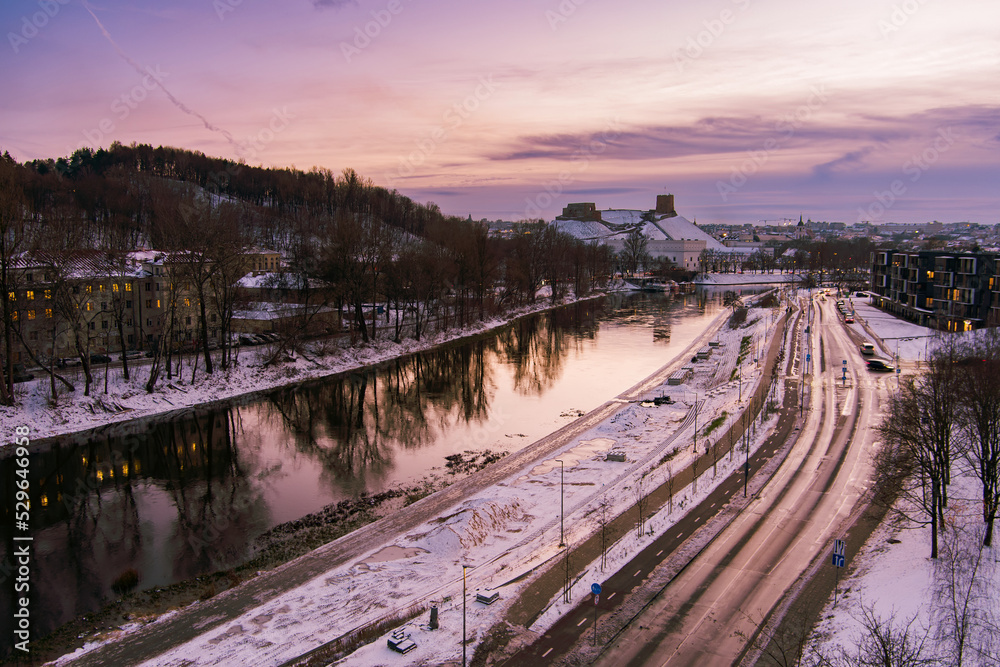 Beautiful Vilnius city panorama in winter with snow covered houses, churches and streets. Aerial sunset view. Winter city scenery in Lithuania.