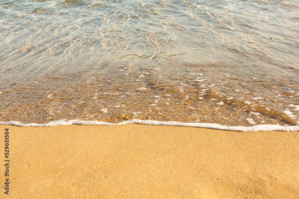 Background with golden sand on the coast of the island of Crete. Abstract surface with sand and clear sea water for text. Background with golden sand on the coast of the island of Crete. Abstract surface with sand and clear sea water for text.