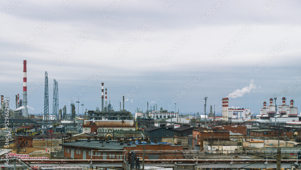View of the oil refinery.  Production equipment at a petrochemical plant. Oil refining production. Smoke from the pipes at the factory. Oil refining and gasoline production.