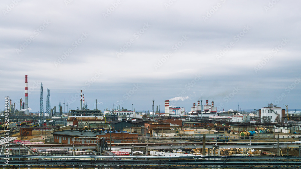 View of the oil refinery.  Production equipment at a petrochemical plant. Oil refining production. Smoke from the pipes at the factory. Oil refining and gasoline production.