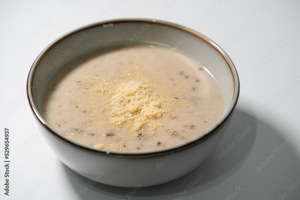 Homemade mushroom soup with parmeson cheese topping in stoneware bowl isolated on white background. Homemade mushroom soup with parmeson cheese topping in stoneware bowl isolated on white background.