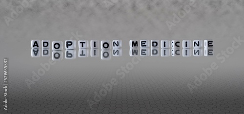 adoption medicine word or concept represented by black and white letter cubes on a grey horizon background stretching to infinity