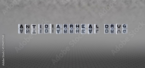 antidiarrheal drug word or concept represented by black and white letter cubes on a grey horizon background stretching to infinity