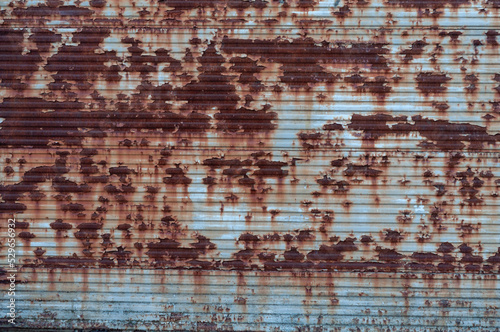 Old rusty metal vintage texture, rough surface background peeled off cracked blue paint, weather-affected material.