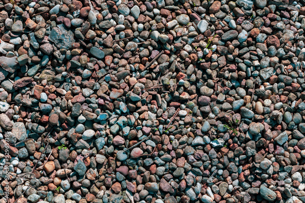 Small smooth stones close-up, small debris among the stones, horizontal background. Small smooth stones close-up, small debris among the stones, horizontal background.