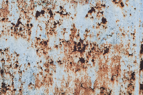 old rusty sheet of metal with peeling faded paint, covered with dust and dirt, grungy texture surface, close-up vintage background.
