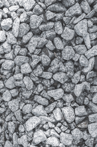 Background of small granite stones close-up, black and white shades on the crushed stone fraction.