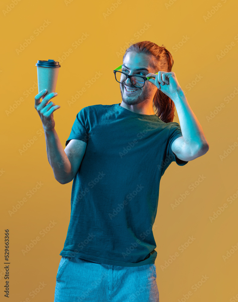 Young handsome guy in glasses with a glass of coffee on a colored background
Young handsome guy in glasses with a glass of coffee on a colored background