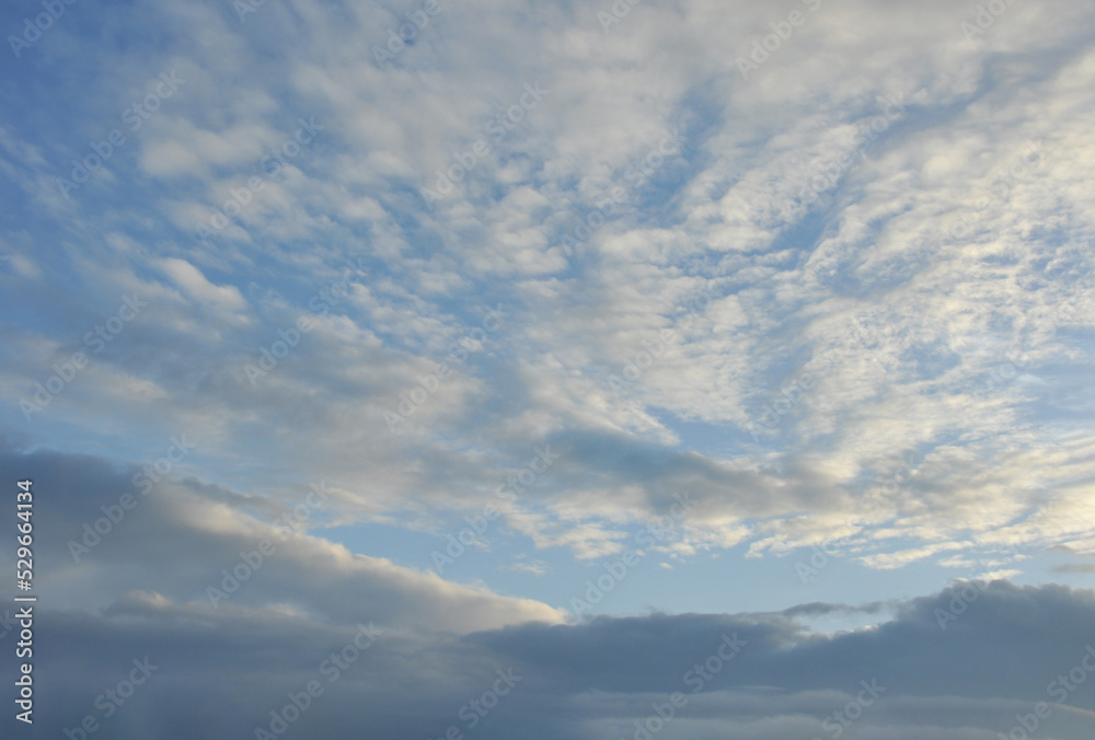 beautiful white clouds and blue sky in higher atmosphere and dark grey clouds in lower atmosphere with evening sunlight in rainy season